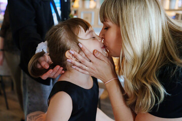 Mother shares a tender kiss with her young daughter