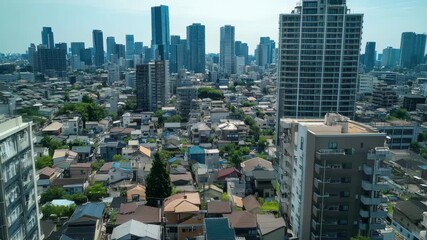 A panoramic view captures a bustling city filled with high-rise skyscrapers alongside traditional houses. Green areas are interspersed throughout this urban setting.