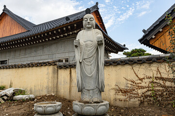 Korean style Buddha stone statue with traditional houses on the background in South Korea