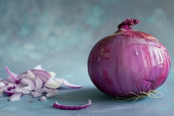 Studio shot of a whole red onion with some of it chopped up on a rustic blue surface