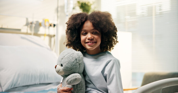 Healthcare, child or smile with teddy bear on hospital bed for surgery recovery, checkup or wellness. African kid, patient or portrait with toy in clinic for pediatrics appointment or healthy healing