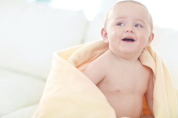 Home, blanket and baby boy with smile, comfort and happiness with fun, relax and calm. Apartment, adorable kid and infant with rest, cozy and growth with wellness, healthy and cute in living room