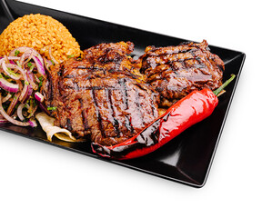 Delicious grilled steak with rice and vegetables served on a black plate