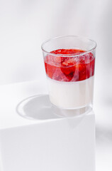 Delicious strawberry dessert in a clear glass on a simple surface