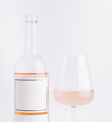 Elegant bottle and glass of rosé wine on a clean white background