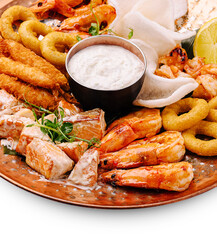 Seafood platter with shrimp, fish, and dipping sauce served on a copper plate