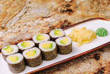Fresh sushi rolls served on a plate with ginger and wasabi