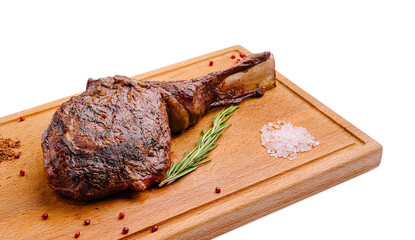 Deliciously cooked ribeye steak on a wooden cutting board with herbs