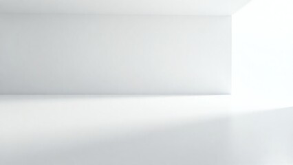 An empty minimalist room with white walls and floors, bathed in soft natural light. This abstract interior serves as a perfect isolated backdrop for winter celebration decorations or product display