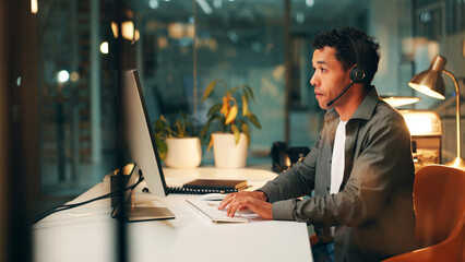 Night, call center and man in office, computer and customer support with system solution. Late,...