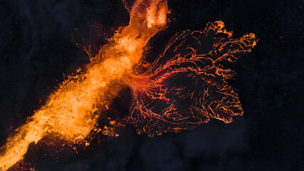 Aerial view of molten lava flows like fiery veins across the dark landscape, a raw display of nature's power in Grindavikurber, Iceland.