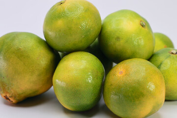 Heap Of Citrus Fruits With Green Peel. Could Represent Limes, Green Tangerines Or Unripe Oranges. Freshness And Sour Taste Concept.