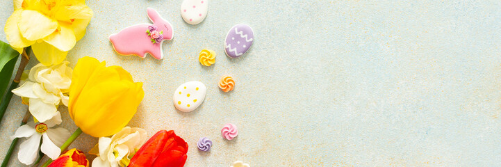 Bright tulips and daffodils surround playful Easter cookies and candies, showcasing the vibrant spirit of springtime festivities and holiday celebrations, banner