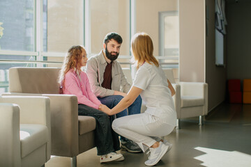 Nurse comforting girl in clinic waiting room