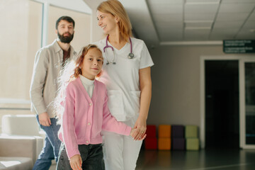 Obraz premium Doctor leading child patient with parent in clinic