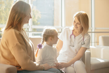 Obraz premium Female doctor comforting child and mother in clinic
