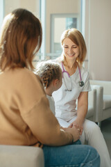 Obraz premium Doctor gently consulting with mother and child in clinic