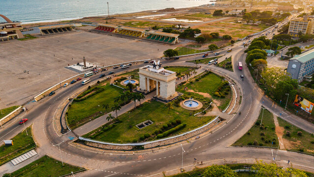Aerial view of the iconic Black Star Gate, a monument framed by a circular road embracing green lawns and fountains, Accra, Ghana.