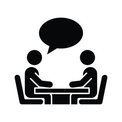 Two people sitting at a table having a conversation, discussion, or interview