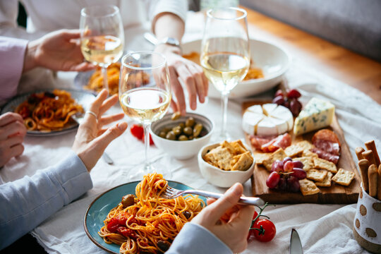 Friends having a pasta dinner with wine at home.