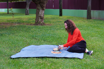 woman preparing a picnic lunch in a park pizza and salad