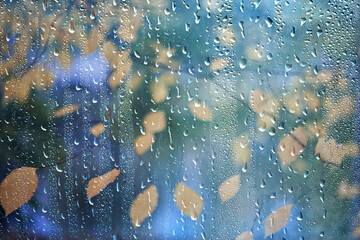 Wet glass, rainy weather, autumn background, rain in the park, blurred abstract backdrop