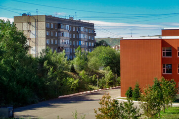 Multi-storey residential building and secondary school. Old and new buildings. Soviet architecture. View. Ust-Kamenogorsk (kazakhstan)