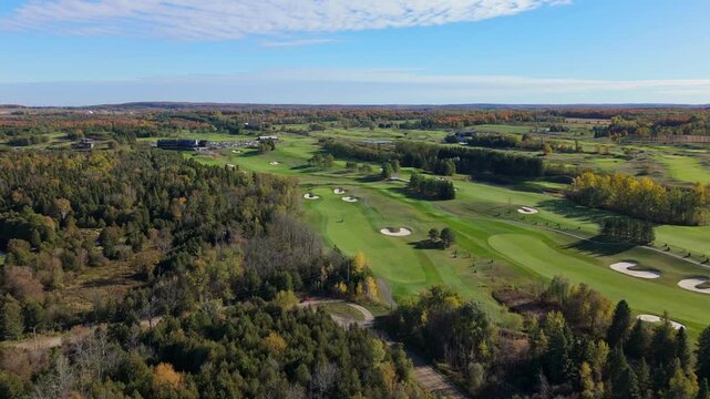 Birds eye view of lush, mowed, and well-trimmed fairways of Golf Course on bright sunny day.