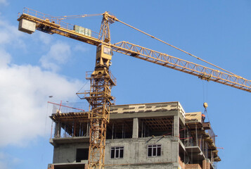 Apartment building under construction. Residential building. Urban grunge. New residential area. Construction site. Construction crane. Blue sky. Ust-Kamenogorsk (kazakhstan)