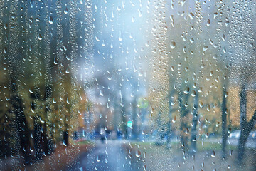 Obraz premium Wet glass, rainy weather, autumn background, rain in the park, blurred abstract backdrop