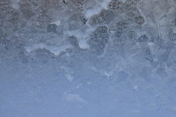 ice pattern on winter glass, abstract background on a cold sunny day