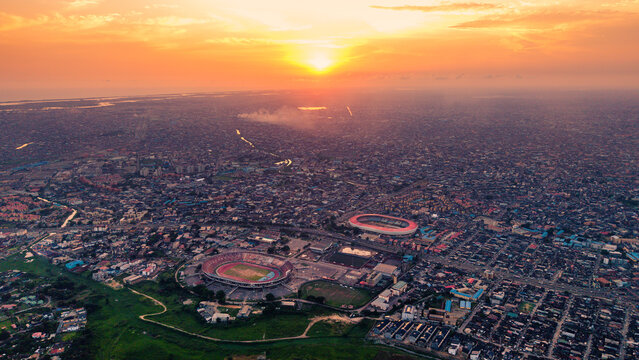 Aerial view of the vibrant cityscape and the stadium bathed in the warm glow of the setting sun, Lagos, Nigeria.
