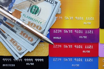 Credit cards and pen with US dollar currency money bills banknotes. Business, financial operations and accounting in United States of America