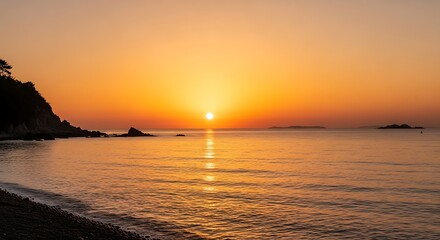 Golden sunset over a tranquil ocean with a rocky coastline
