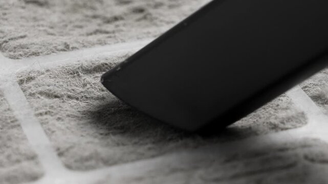 Vacuum cleaner removing dust from dirty clogged air conditioning and ventilation system filter