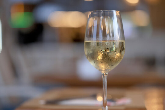 a glass of cold white wine and serving in the restaurant