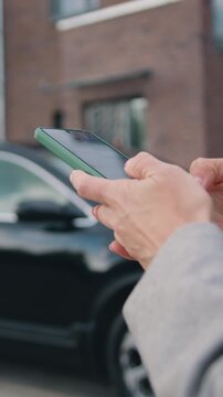 Close up of female hands holding phone, typing on screen, chatting in social network, writing message, browsing mobile device apps at area outdoors. Slow motion