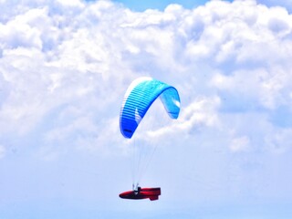 THE BEAUTY OF MOUNT GAJAH TELOMOYO PARALAGLIDING ATHLETES FLYING IN A SEA OF CLOUDS AND A BLUE SKY