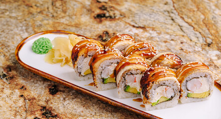 Sushi rolls arranged neatly on a platter with ginger and wasabi