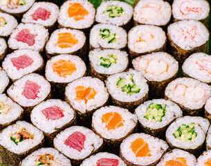Sushi rolls displayed neatly on a platter with various fillings
