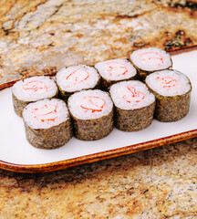 Sushi rolls with shrimp served on a plate in a beautiful restaurant setting