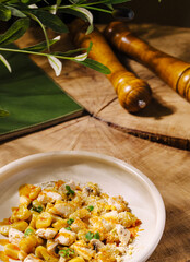Delicious pasta dish served on rustic wooden table with greenery