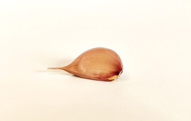 A clove of garlic on a white background with a shadow. Isolate