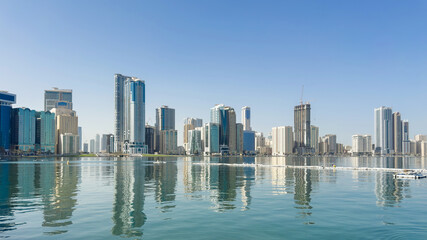 Fototapeta premium Clear morning scene view from Al Majaz Waterfront in Sharjah, UAE, open water and distant towers