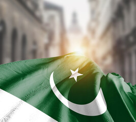 Pakistan flag fluttering on blur street with building. Pakistan national flag for independence day.