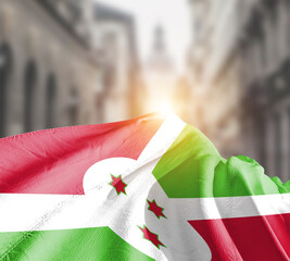 Burundi flag fluttering on blur street with building. Burundi national flag for independence day.