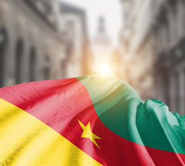 Cameroon flag fluttering on blur street with building. Cameroon national flag for independence day.