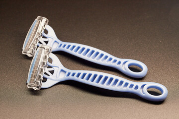 Close-up of two new disposable razors on a gray background