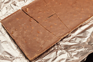 Close-up of a milk chocolate bar with nuts in foil