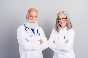 Two experienced doctors pose in white coats ready for a health care consultation showing collaboration and care in a clinic setting